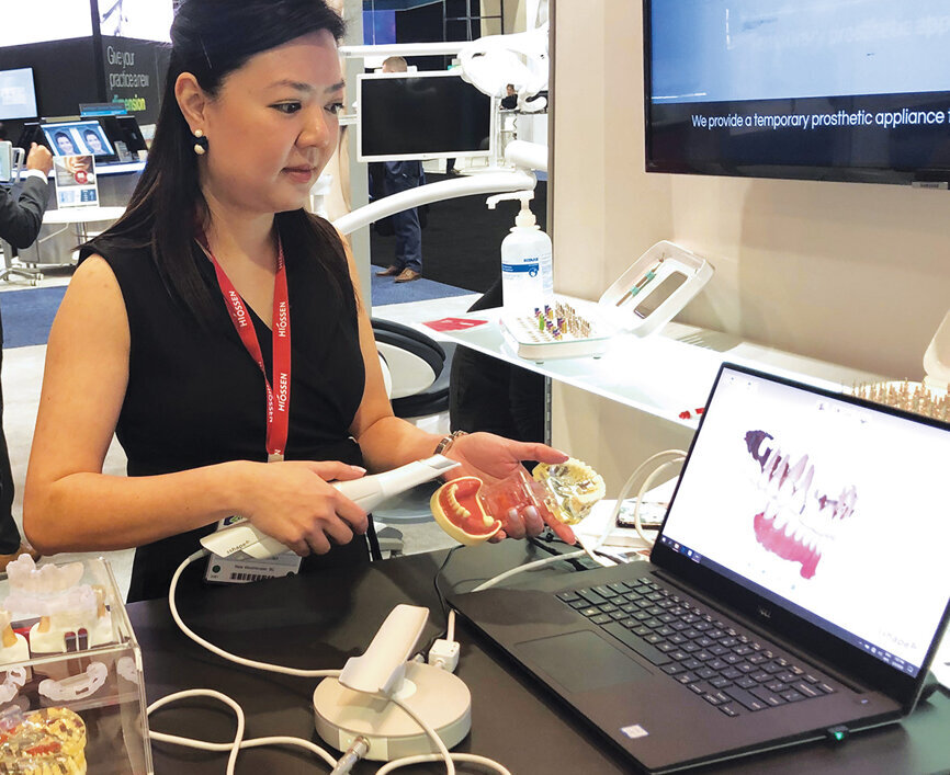Winnie Co of Hiossen Implant Canada demonstrates one of the booths many products on display.