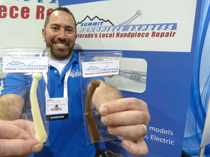Displaying what are likely the world’s only chocolate handpieces, available in white chocolate and milk chocolate, is Richard Ball, co-owner with wife Kelly of Summit Handpiece Express. (Photo: Robert Selleck/Dental Tribune America)